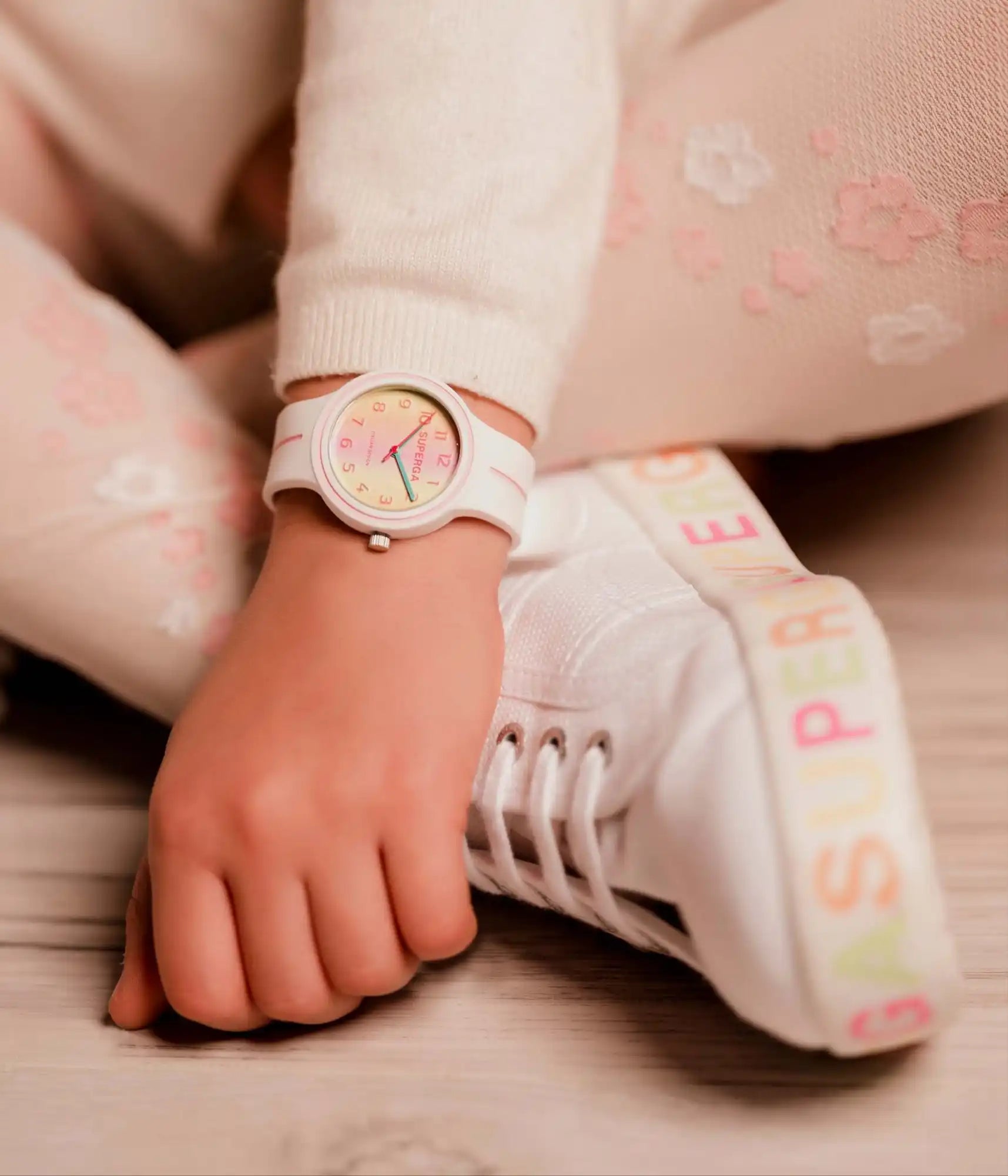Un orologio da polso bianco per bambini con una faccia colorata.