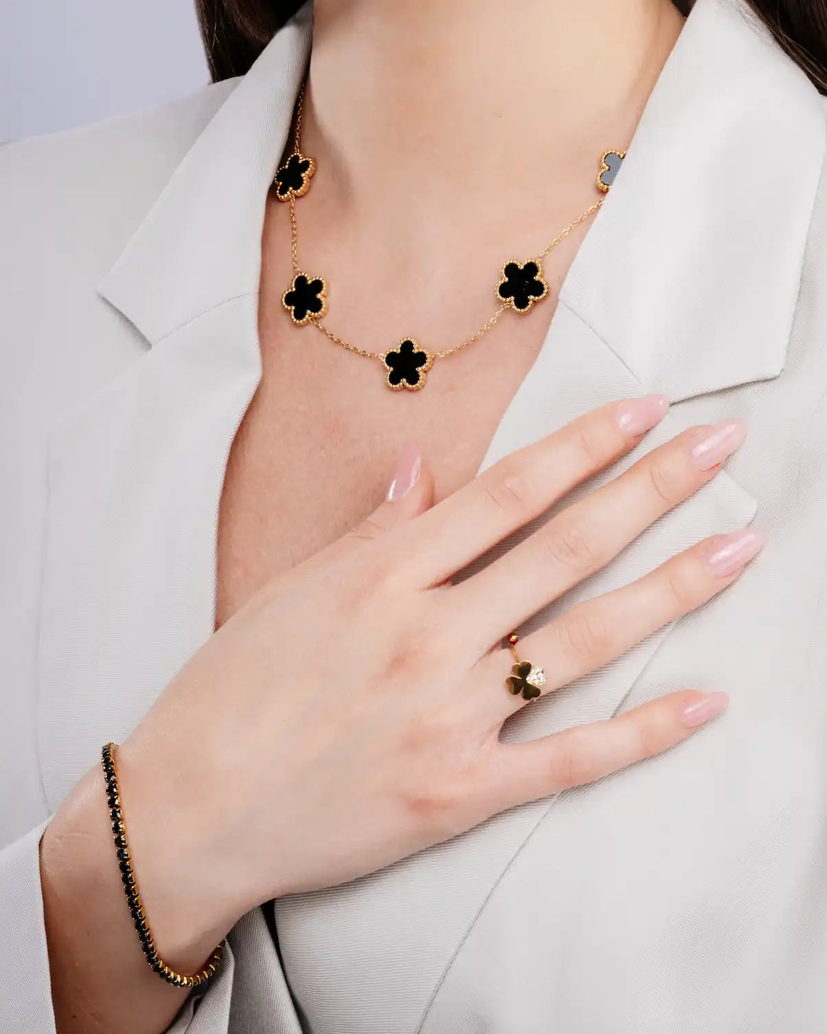 Set di gioielli in oro e quadrifoglio nero.