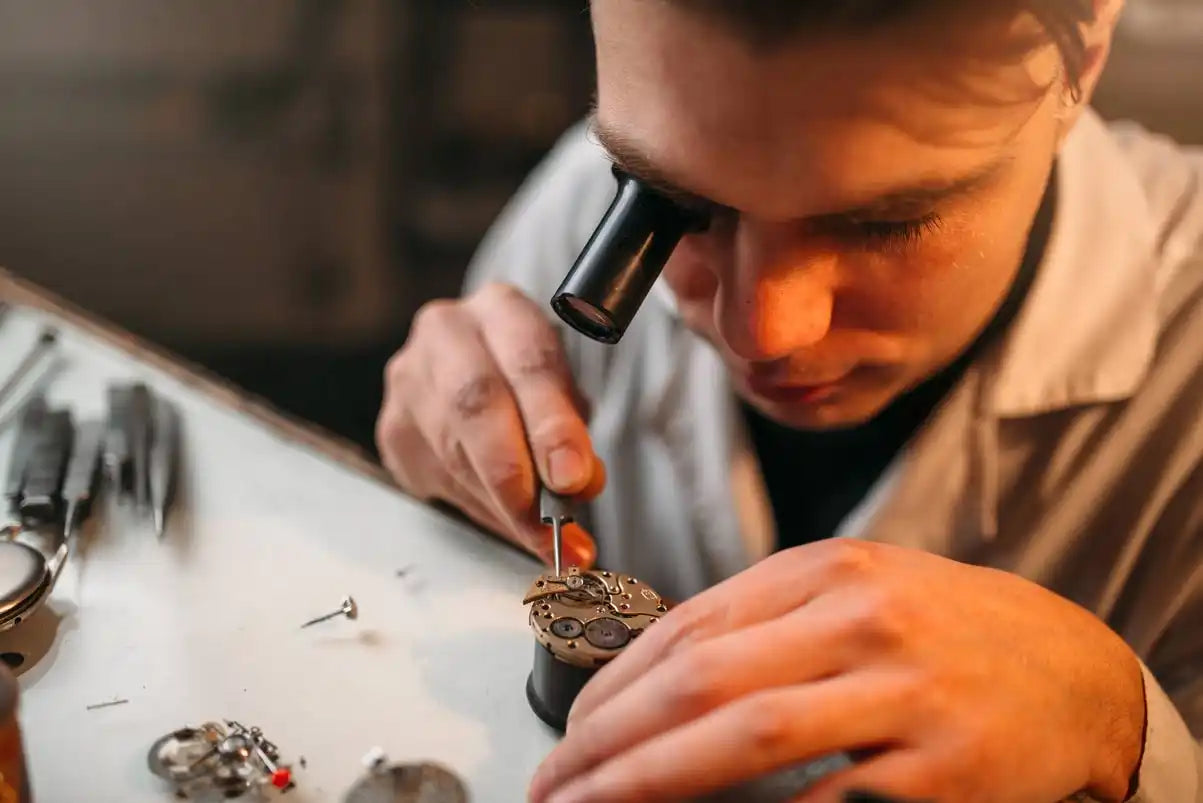 Orologiaio che ripara un orologio.